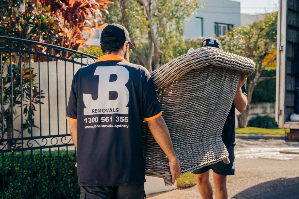 JB Removals crew carrying protected furniture outdoors