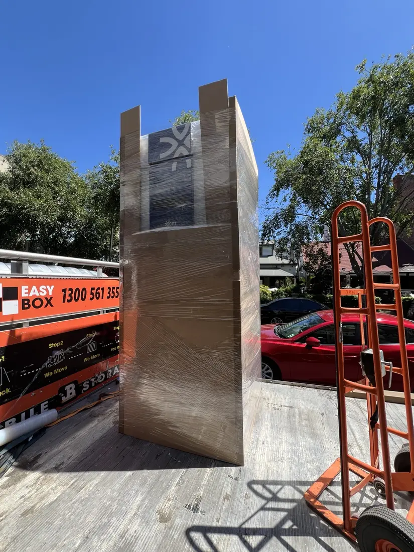 A 250 kg commercial refrigerator fully wrapped and protected with a custom MDF shell on a JB Removals truck