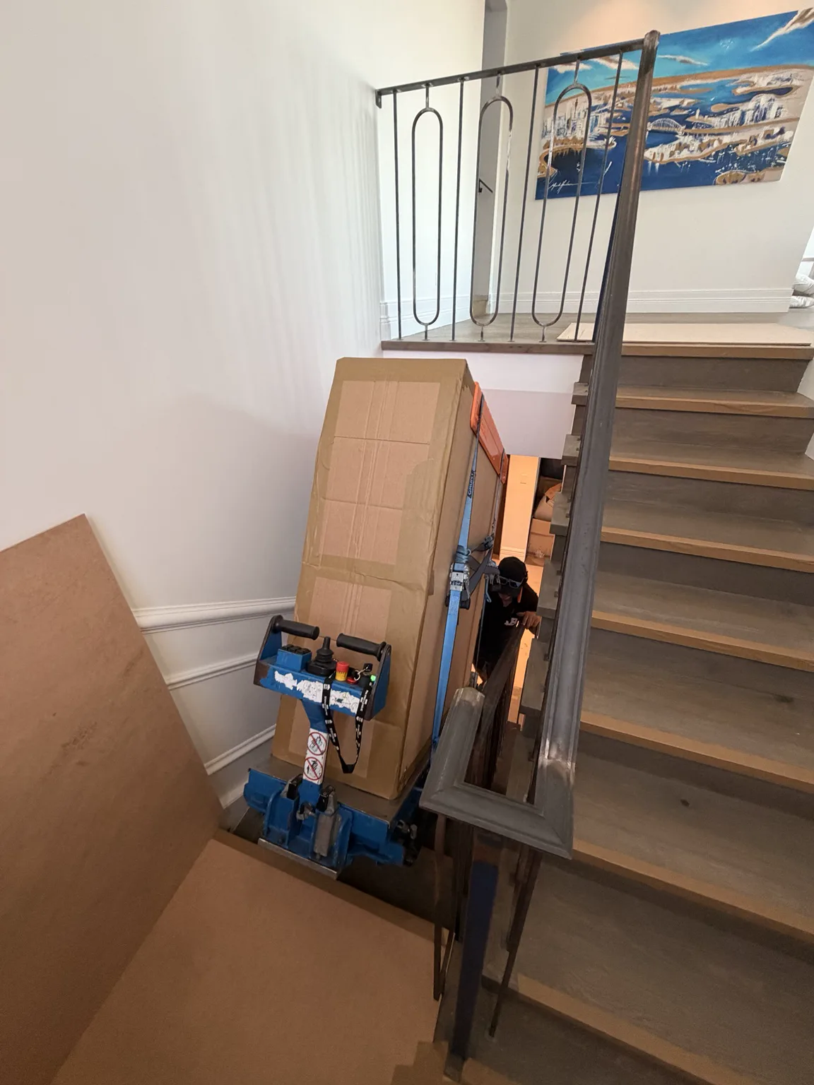 JB stair-climber team moving a protected marble table on a tight staircase