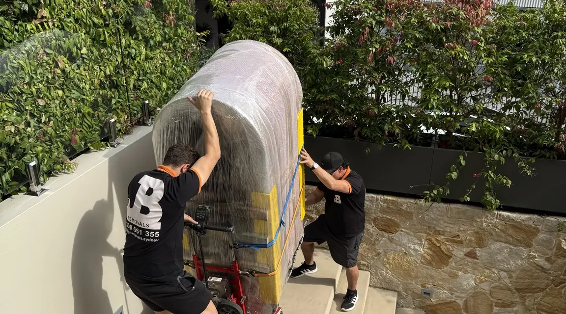JB specialists moving a protected ice bath on outdoor stairs