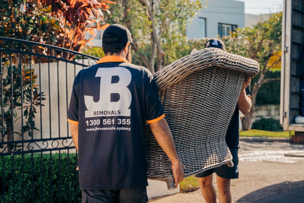 JB Removals crew carrying protected furniture during a home move