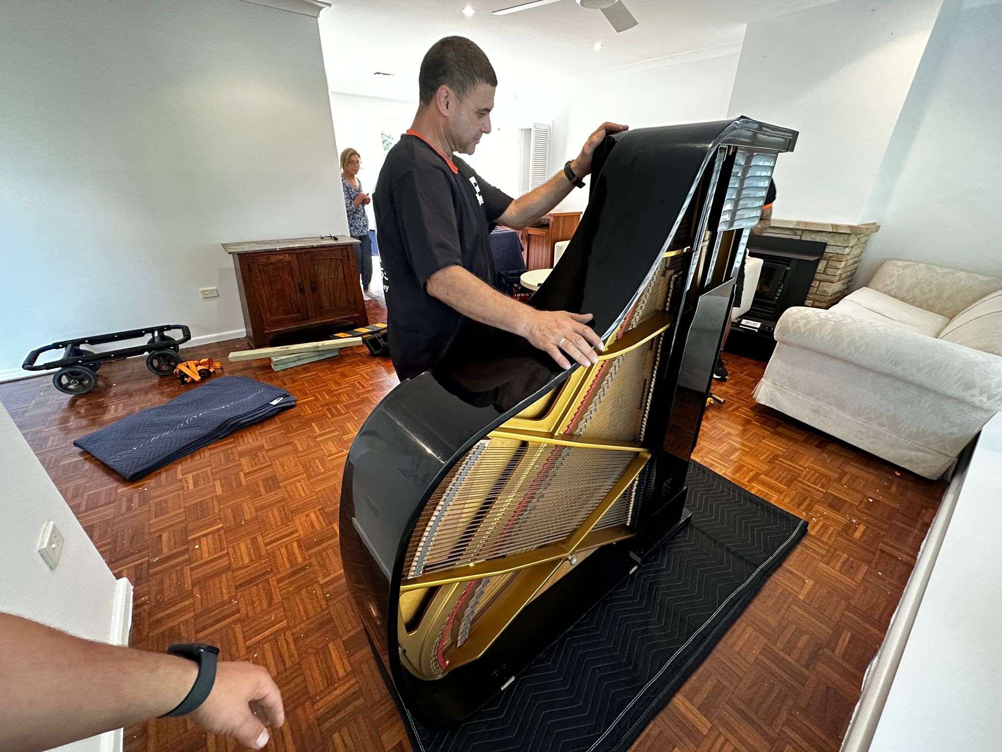 JB Removals preparing a grand piano with floor protection and specialist equipment