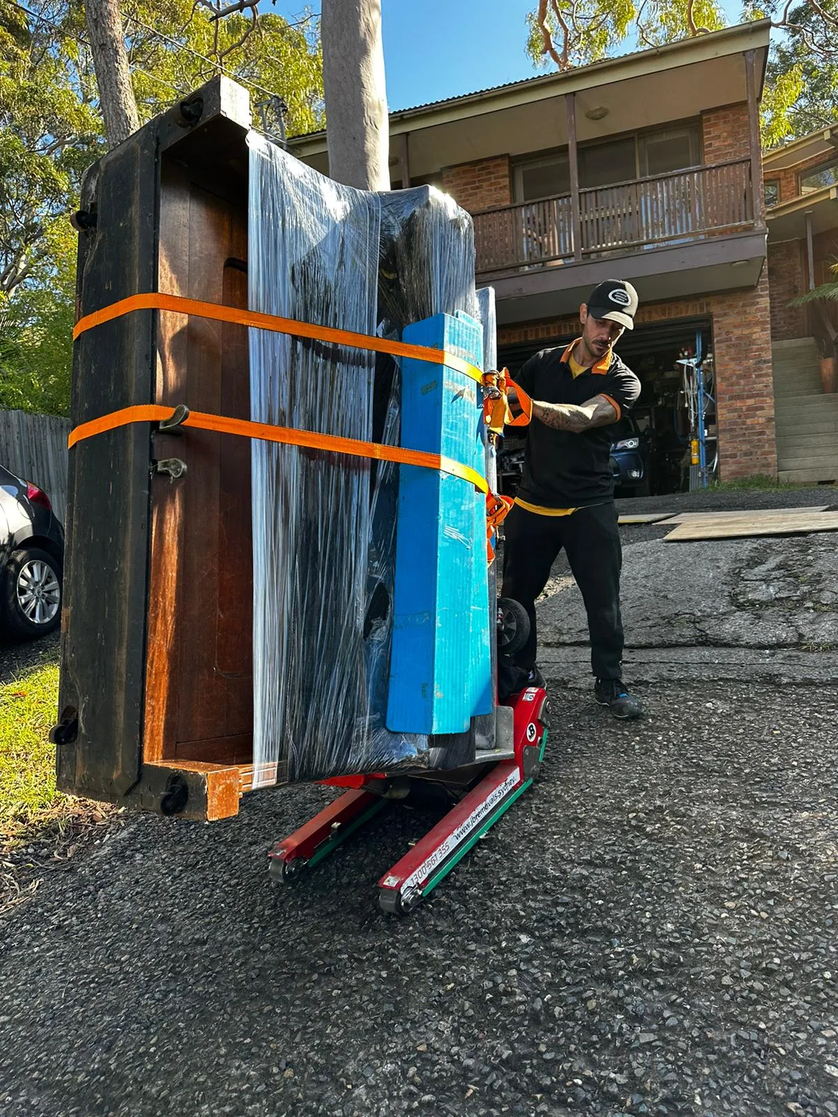 Protected upright piano on specialist equipment outside a Sydney home