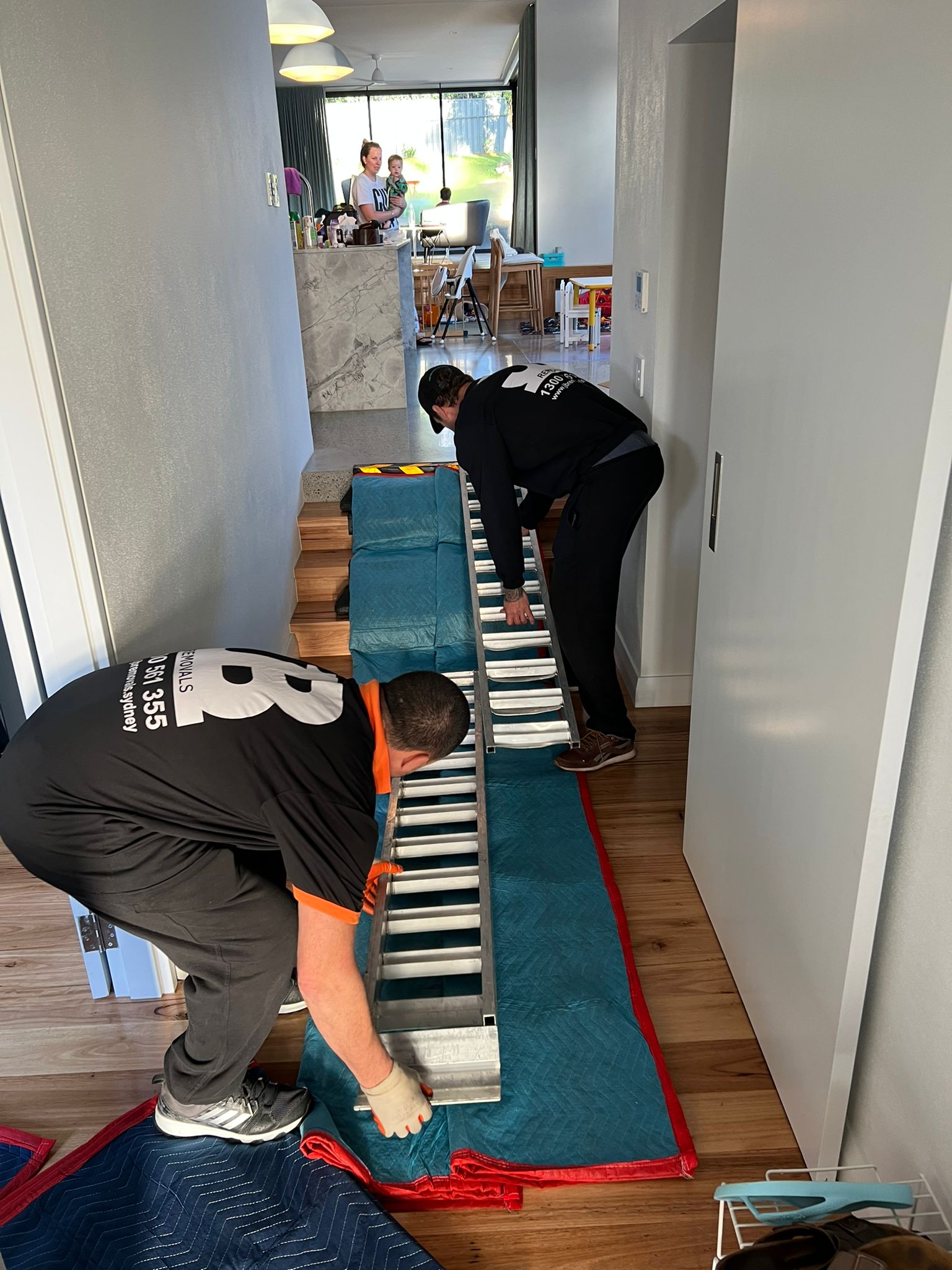 JB Removals crew laying protective blankets and aluminium ramps over timber flooring