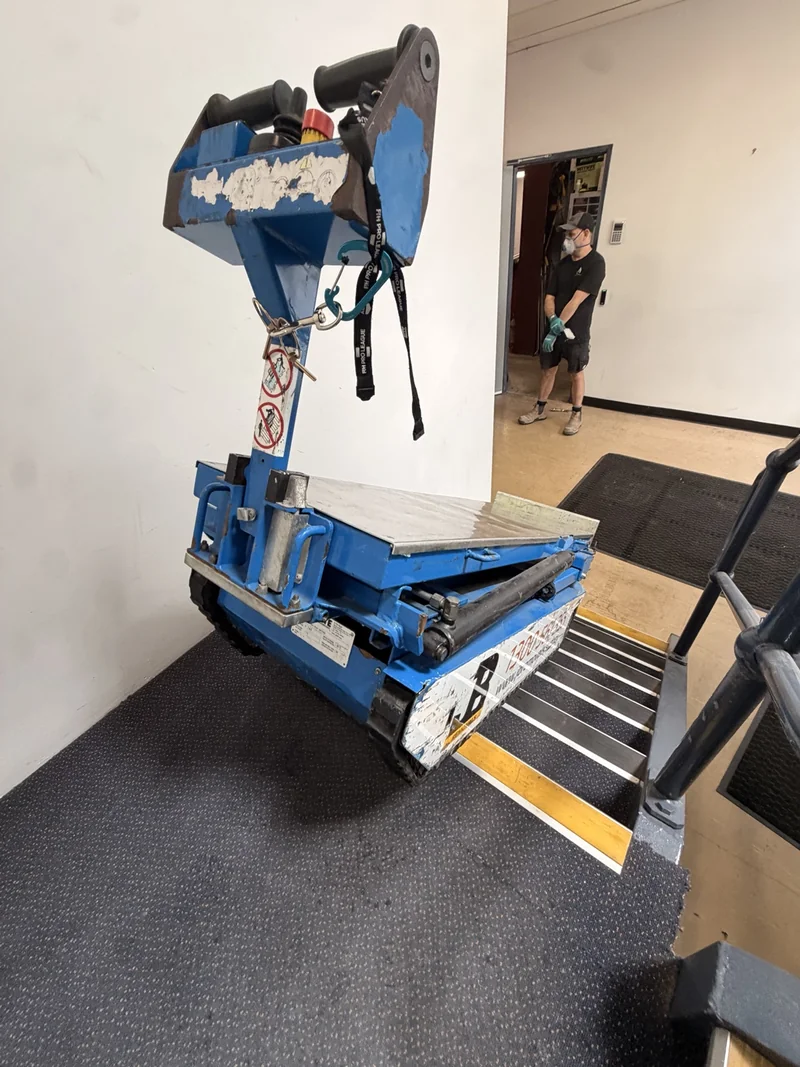Blue JB powered stair climber positioned beside the internal stair landing