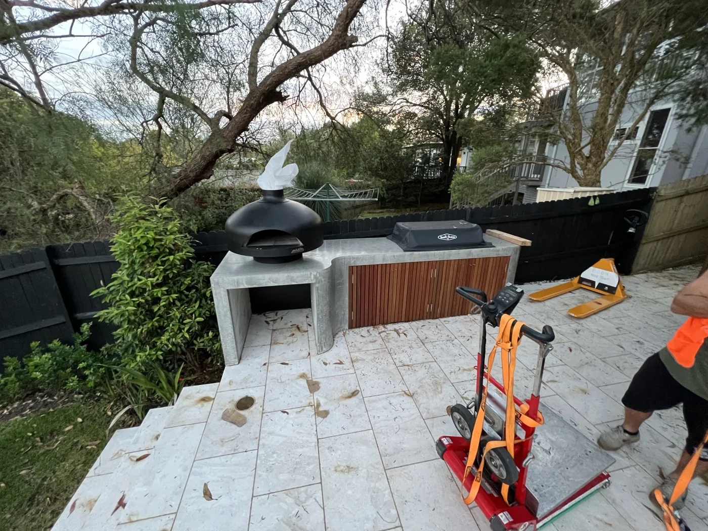 Relocated pizza oven resting on a concrete outdoor kitchen slab