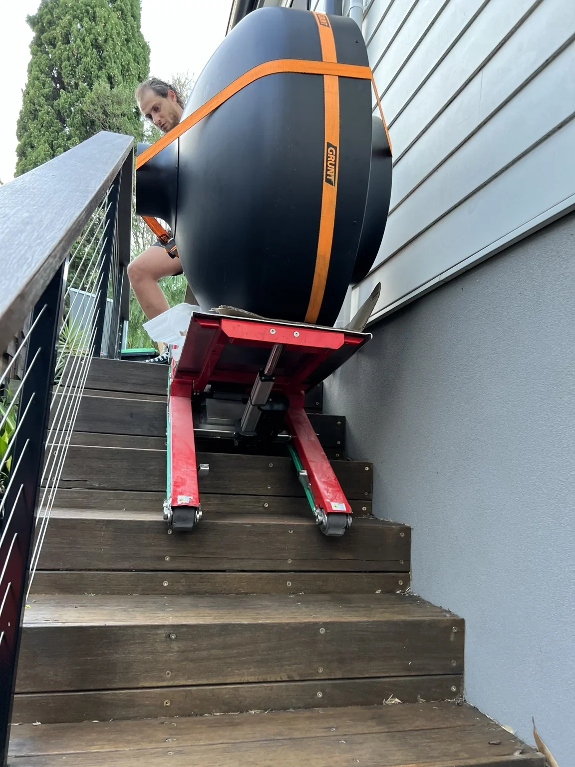 Close view of a pizza oven on JB’s stair climber beside a house wall