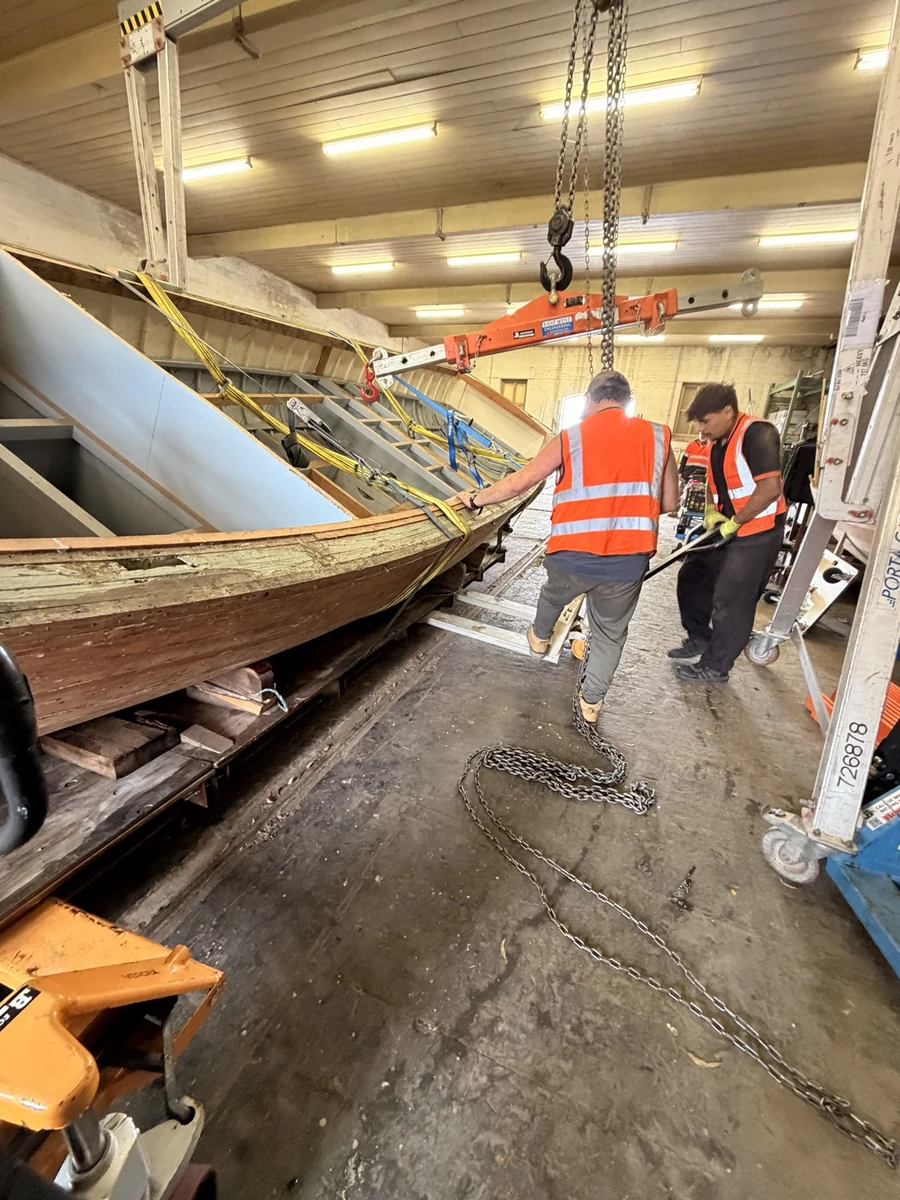 JB crew working beside the supported boat inside the warehouse