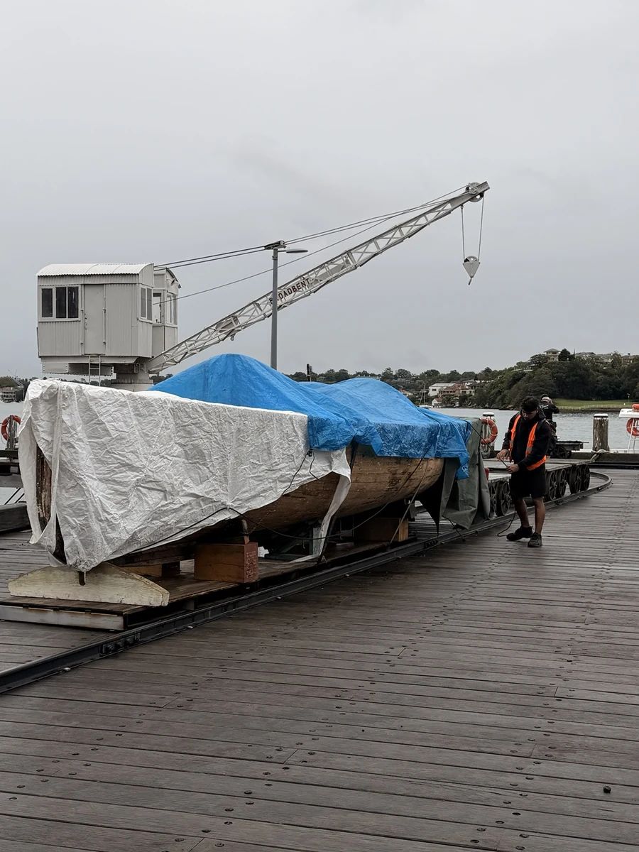 Covered boat supported outside on the waterfront after extraction