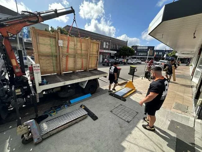 Large timber crate on a truck outside the salon with crane equipment visible