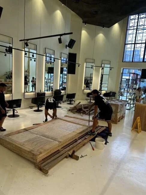JB team dismantling timber packaging inside the salon