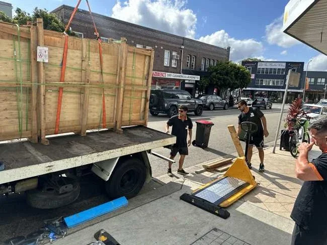 JB team beside the truck and large timber crate outside the salon