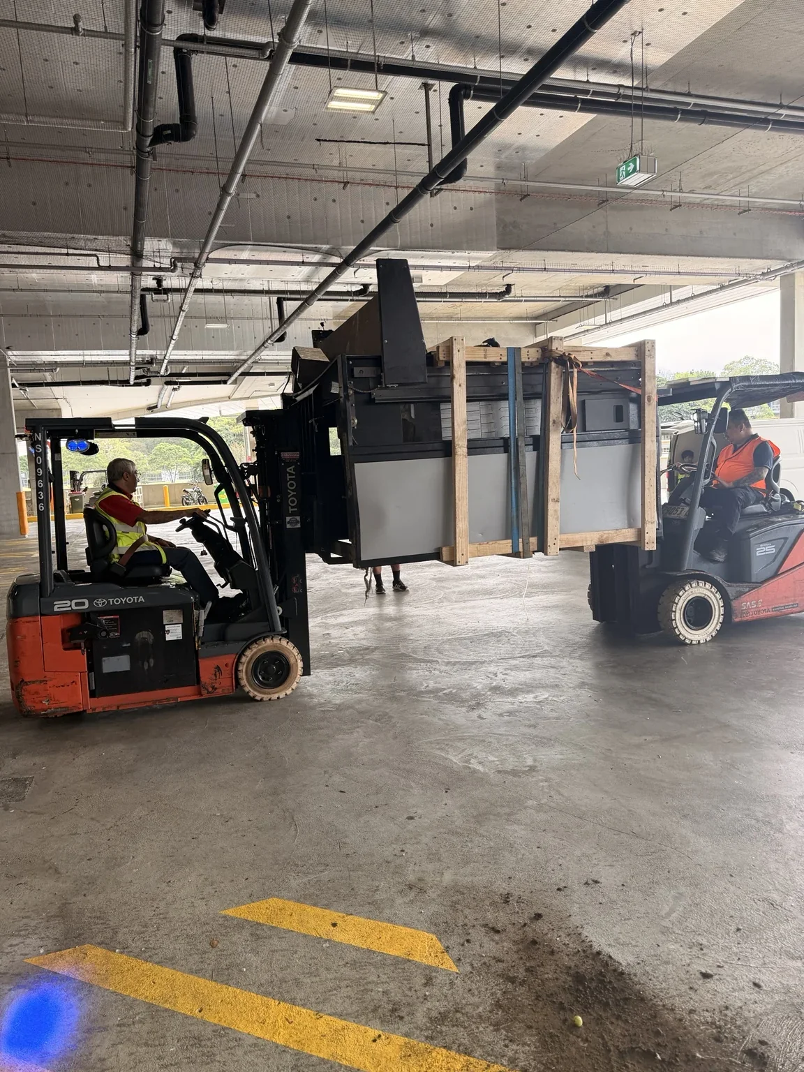 Two forklifts beside the timber-framed commercial oven in the receiving area