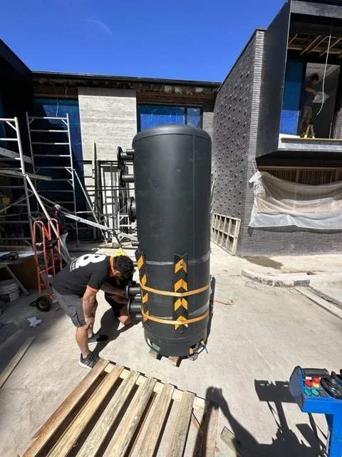 JB removalist preparing a tall cylindrical water-heating vessel with securing straps