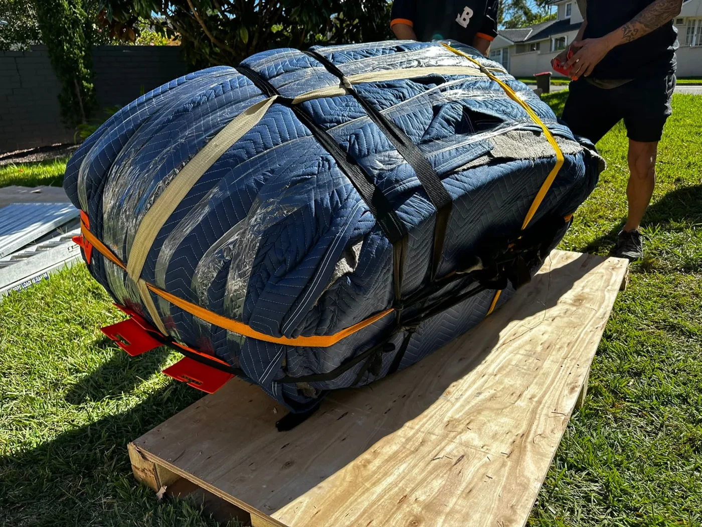Wrapped bath held on its side with straps and moving fixtures over timber boards