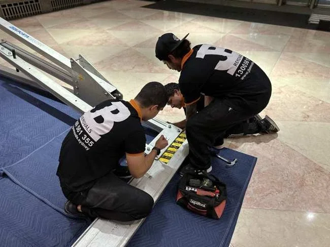 JB team working on the gantry frame components on floor blankets