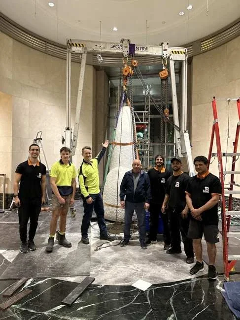 Project team standing in the lobby beside the gantry and tall marble section