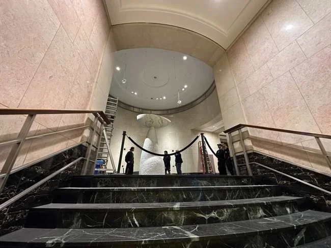 Lobby stairs with the marble sculpture visible beyond the landing