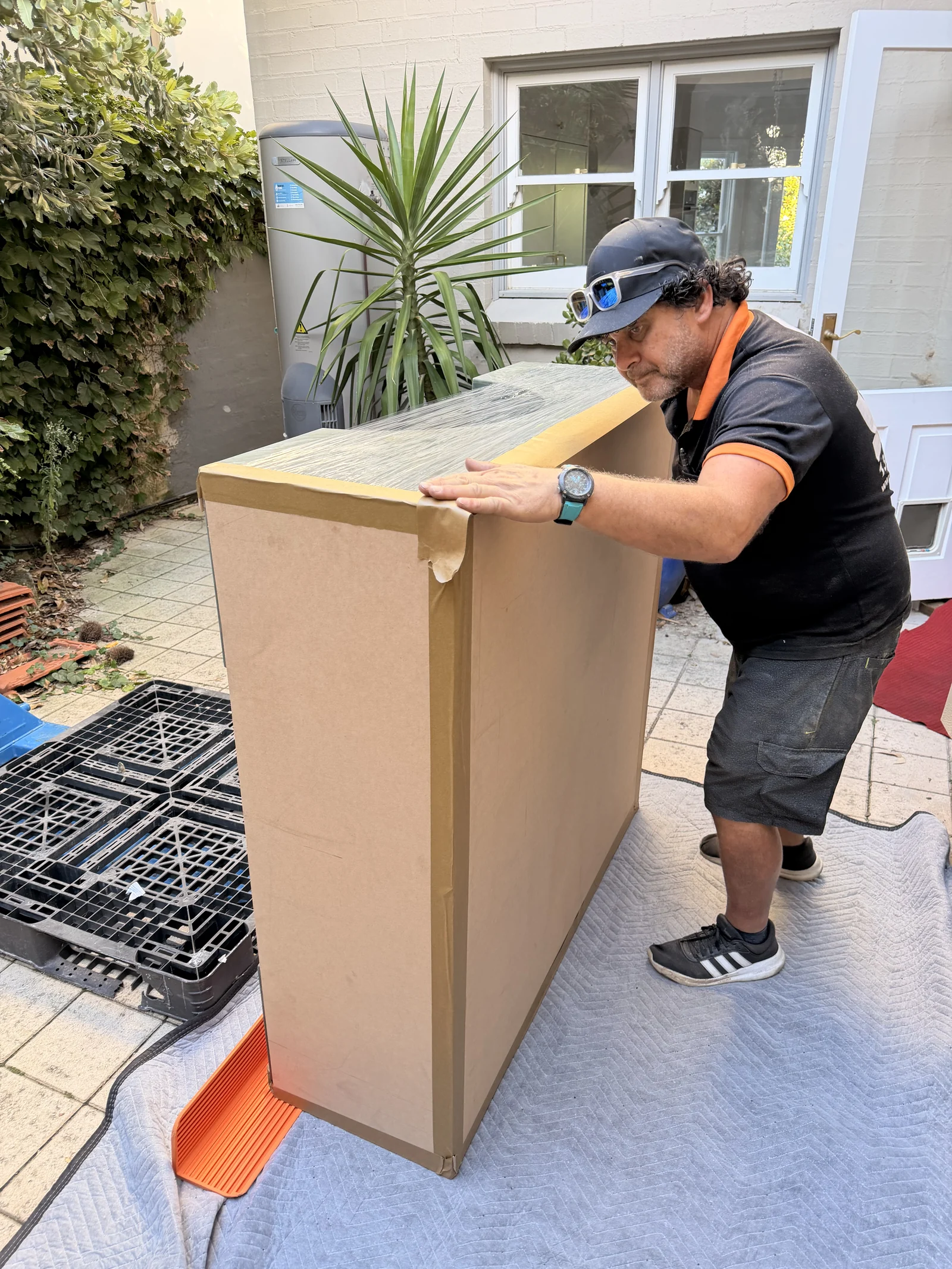 JB crew positioning rigid protection around the marble table outdoors.