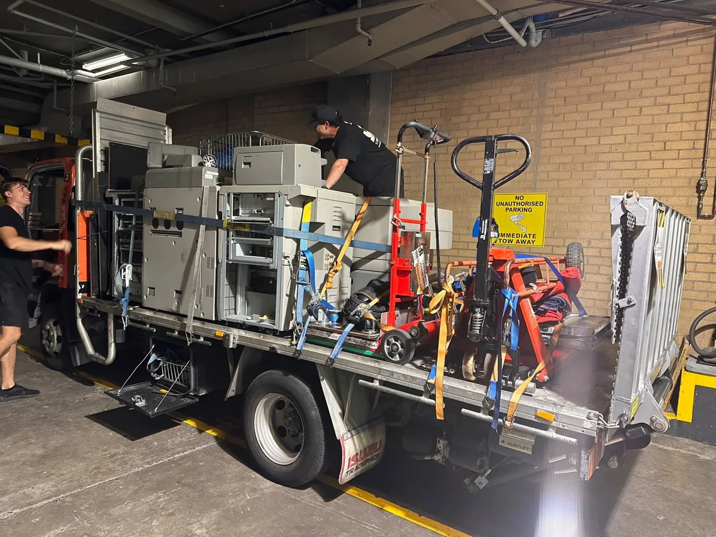 JB crew with commercial print equipment and moving tools on a flatbed truck
