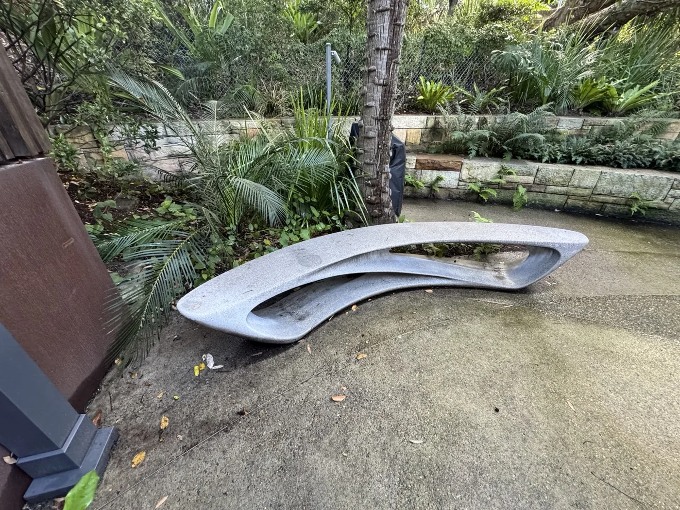 Long curved marble bench in a garden setting