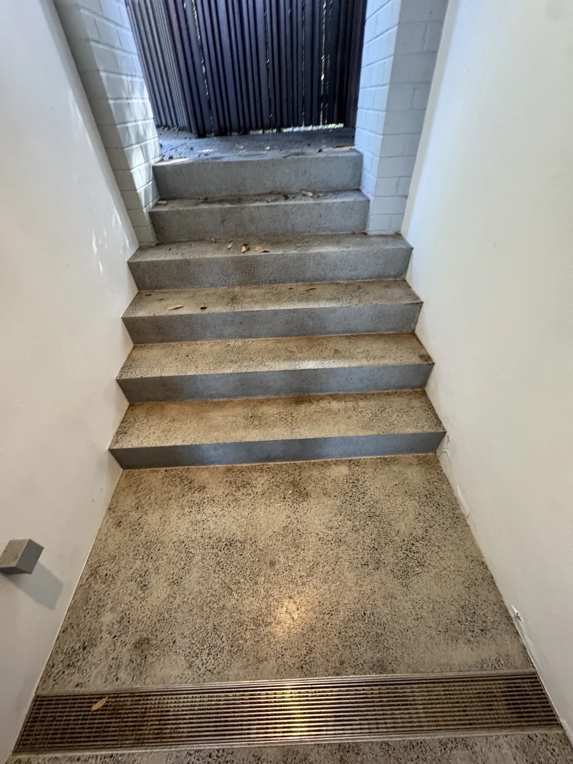 Narrow concrete staircase between walls at the marble bench moving route