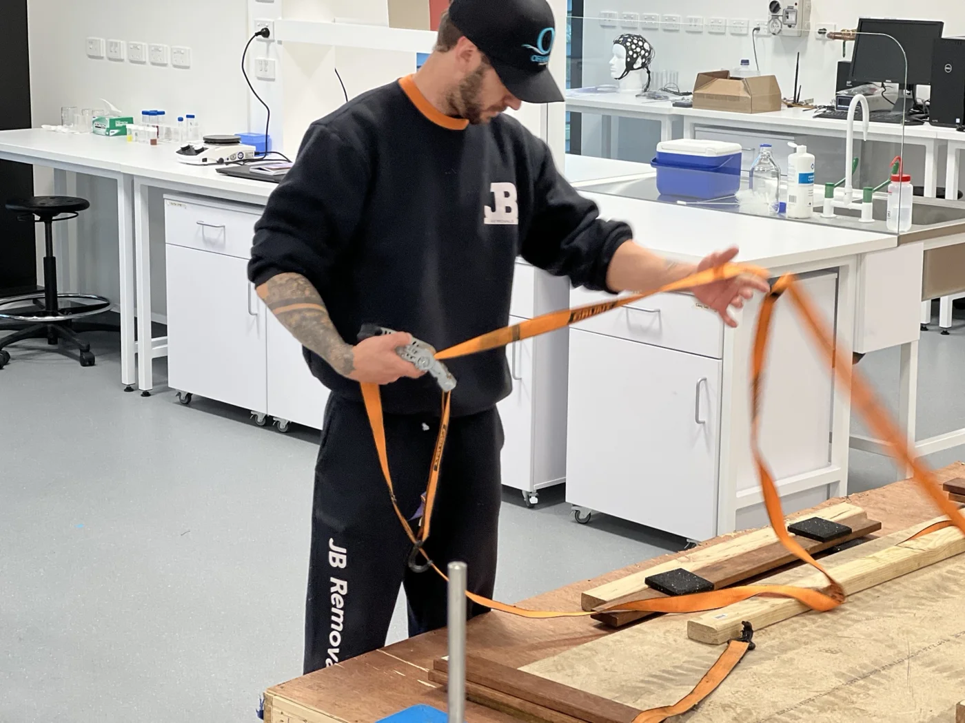 JB removalist handling orange straps beside the optical table transport packing
