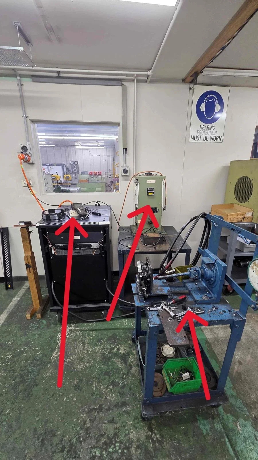 Control cabinets and bench-mounted equipment marked with arrows for the warehouse move