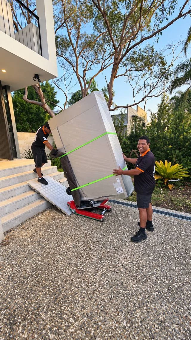 JB movers handling a wrapped fridge with a stair climber and ramp