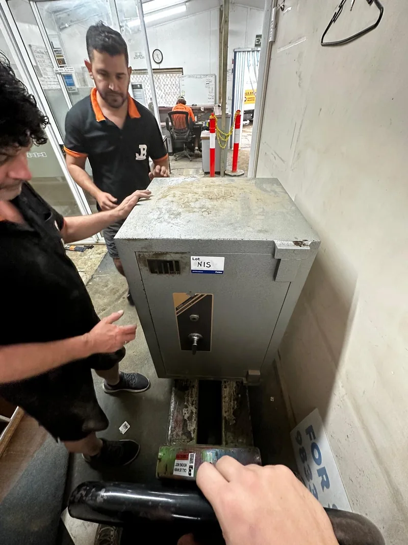 JB Removals crew beside the 450 kg safe and moving equipment in a narrow passage in Sydney