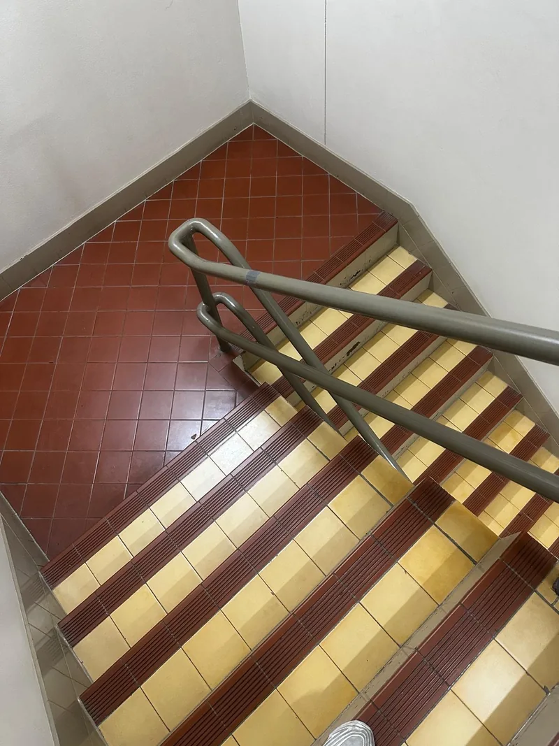 Turning tiled staircase landing with metal handrails on the safe-moving route