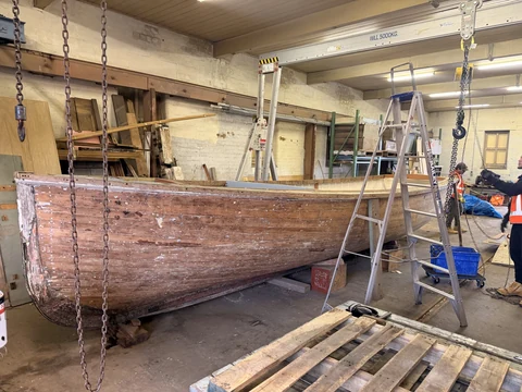 JB Removals: Boat inside the warehouse with gantry lifting equipment positioned around the hull
