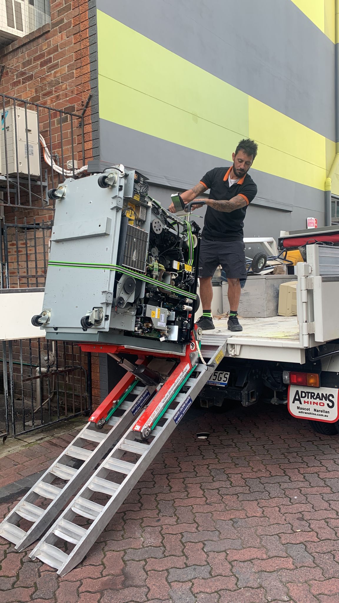 JB Removals specialist loading heavy commercial equipment onto a truck using a powered stair climber